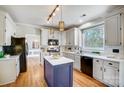 Modern kitchen with white cabinets, center island, and stainless steel appliances at 9236 Silver Pine Dr, Charlotte, NC 28277