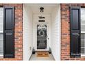 Inviting front entrance with brick facade, black shutters, and a welcoming mat at 10122 Oxford Landing Ln, Charlotte, NC 28270