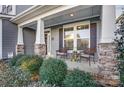 Relaxing front porch with stone accents and lush landscaping at 1026 Slew O Gold Ln, Indian Trail, NC 28079