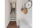 Clean and bright staircase with hardwood floors and storage bench at 1326 Gleason Way, Charlotte, NC 28217