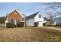 Two-story house with brick and white siding, a two-car garage and landscaping at 16220 Circlegreen Dr, Charlotte, NC 28273