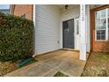 Black front door with a small porch and sidelight window at 16220 Circlegreen Dr, Charlotte, NC 28273