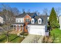 Two-story house with a brick facade, attached garage, and manicured lawn at 2003 Galty Ln, Charlotte, NC 28270