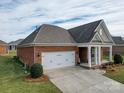 Brick home with a two-car garage and partial view of backyard at 2836 Santiago Cir, Monroe, NC 28110