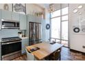 Stainless steel appliances and light blue cabinets in this modern kitchen at 300 Magnolia Ave # 301, Charlotte, NC 28203