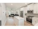 Open concept kitchen with island, stainless steel appliances, and views of the living room at 5048 York Park Ln, Charlotte, NC 28217