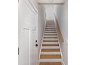 Bright stairway featuring wood treads, white risers, and a natural wood handrail at 5048 York Park Ln, Charlotte, NC 28217