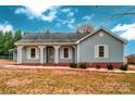 Ranch style home with light blue siding, covered porch, and a grassy yard at 5704 Bentgrass Ct, Monroe, NC 28110