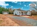 Gray ranch home with covered porch, detached garage, and gravel driveway at 5704 Bentgrass Ct, Monroe, NC 28110