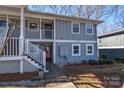 Gray siding condo with white trim, steps, and a small yard at 7608 Woods Ln # 12, Cornelius, NC 28031