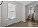 Bright entryway with hardwood floors, stairs, and a large clock at 7840 Denmark Rd, Charlotte, NC 28273