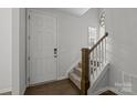 Front door and staircase in a light and airy entryway at 7840 Denmark Rd, Charlotte, NC 28273