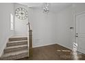 Stylish carpeted staircase with wooden railing in a light-filled entry at 7840 Denmark Rd, Charlotte, NC 28273