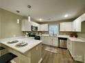 Modern kitchen featuring white cabinets and a breakfast bar at 808 Eastview St, Shelby, NC 28152