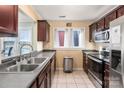 Functional kitchen featuring stainless steel appliances, dark wood cabinets, and a double sink at 9037 J M Keynes Dr # 23, Charlotte, NC 28262