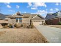 Charming single-story home with a brick facade, attached garage, and well-maintained landscaping on a sunny day at 9428 Liberty Hill Dr, Mint Hill, NC 28227