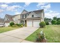 Two-story house with stone and shingle accents, two-car garage, and landscaped front yard at 1344 Middlecrest Nw Dr, Concord, NC 28027