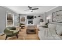 Living room with a fireplace, light-colored sofa, and two green armchairs at 3433 Grey Rd, Davidson, NC 28036
