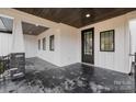 Covered porch with stone pillars, dark wood ceiling, and modern tile flooring at 177 Olympia Dr, Mooresville, NC 28117