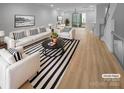 Virtually staged living room with striped rug and modern furniture at 2124 Electric Ln, Charlotte, NC 28205