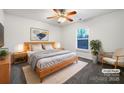 Virtually staged main bedroom with light wood furniture and a ceiling fan at 3522 Larkhaven Village Dr, Charlotte, NC 28215