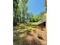 Expansive backyard with a gentle slope, mature trees, and a view of the home's exterior at 395 Paulownia Dr, China Grove, NC 28023