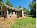 Charming brick home featuring a lush green lawn and mature trees in a peaceful setting at 395 Paulownia Dr, China Grove, NC 28023
