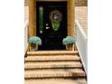 Inviting front entrance with brick steps, potted plants, and a decorative wreath on the door at 395 Paulownia Dr, China Grove, NC 28023