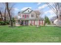 Beautiful two-story home with gray siding, red shutters, and a lush green front lawn at 10111 Grimsby Ct, Huntersville, NC 28078