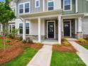 Inviting townhome entrances with stone accents, covered porches, and professionally landscaped yards at 10117 Mamillion Dr, Huntersville, NC 28078