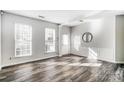 Sunlit living room with hardwood floors and two windows at 15011 Edindale Dr, Charlotte, NC 28277