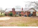 Red brick house featuring a cozy backyard, complete with a patio and convenient carport access at 1715 Emmanuel Church Rd, Conover, NC 28613