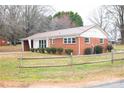 A quaint red brick house with a metal roof and a partially fenced yard at 1715 Emmanuel Church Rd, Conover, NC 28613