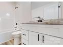 Modern bathroom featuring a white vanity with a light countertop and dark fixtures, complemented by a toilet and shower at 2906 Lathan Rd, Monroe, NC 28112