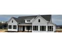 White farmhouse with gray roof and dark shutters, viewed from a distance at 2906 Lathan Rd, Monroe, NC 28112