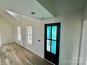 Light-filled hallway with wood-look floors and a black interior door at 2906 Lathan Rd, Monroe, NC 28112