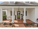 Inviting front porch with brick flooring, white columns, and hanging porch swing at 373 Hillside Ave, Charlotte, NC 28209