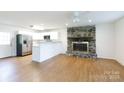 Open-concept living area boasts a stone fireplace, wood floors, and modern kitchen with stainless steel appliances at 3988 Crestview Dr, Rock Hill, SC 29732