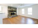 Bright living room features a stone fireplace, wood floors, and ample natural light from two windows at 3988 Crestview Dr, Rock Hill, SC 29732