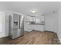 Bright kitchen featuring stainless steel refrigerator, white cabinets, and modern backsplash at 413 Shinnville Rd, Mooresville, NC 28115