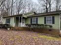 One-story house with green siding, mature trees, and a small yard at 4452 Huntington Dr, Gastonia, NC 28056