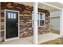 Inviting entrance with stone accents, a black door, white columns and the house number at 4618 Harris Elliot Rd, Lincolnton, NC 28092