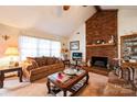 Cozy living room featuring a brick fireplace, ceiling fan, and comfortable brown sofa at 5701 Glenshire Ct, Charlotte, NC 28269