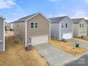 Tan colored two-car garage with driveway at 717 Windage Way, Pineville, NC 28134