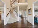 Open entryway featuring beautiful wood floors, staircase, and stylish design elements, including a view to the living room at 8509 Penton Pl, Harrisburg, NC 28075