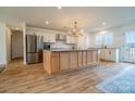 Spacious kitchen featuring an island, stainless steel appliances, white cabinets, and natural wood flooring at 9489 Westridge Dr, Hickory, NC 28601