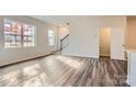 Bright living room with hardwood floors, staircase, and large windows at 9859 Old Garden Cir, Gastonia, NC 28056