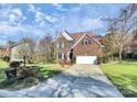 Brick two-story house with a two-car garage and landscaped yard at 10501 Rougemont Ln, Charlotte, NC 28277