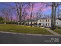 Charming single-Gathering home with traditional architecture, mature trees, and inviting curb appeal at twilight at 1116 Circlewood Dr, Charlotte, NC 28211