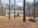 Home's backyard is surrounded by tall trees with a deck at 1194 Great Falls Hwy, Chester, SC 29706